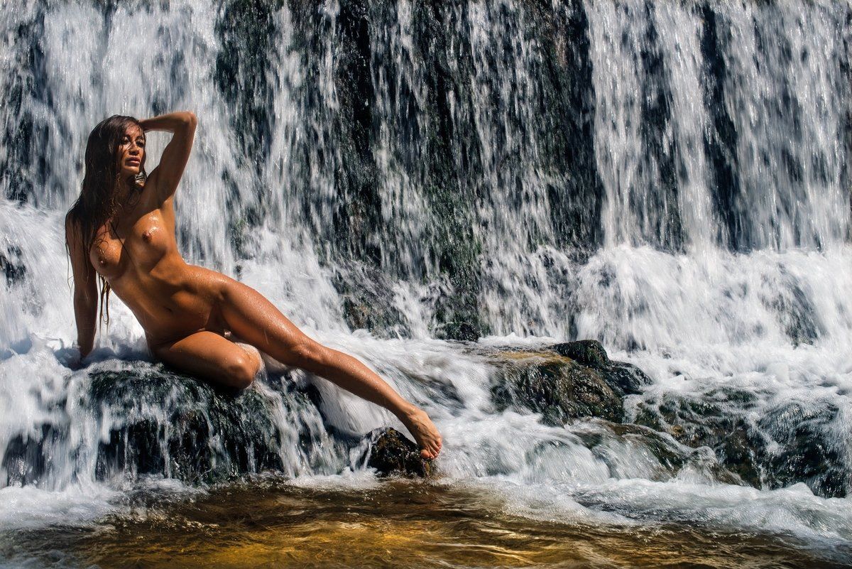 Русская красотка без одежды позирует на фоне водопада и дрочит